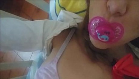 the little girl sucks the pacifier and takes your splash on her pretty face