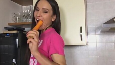 Russian pornstar Nataly Gold rubs her hole with carrot in the kitchen